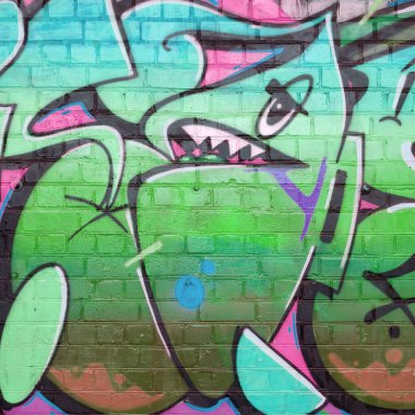 Eski tuğla duvarın üzerine yeşil renkli graffiti resimlerinin soyut bir parçası. Yazılmamış mektupların ve renkli lekelerin olduğu sokak sanatı kompozisyonu. Alt kültür arkaplan dokusu