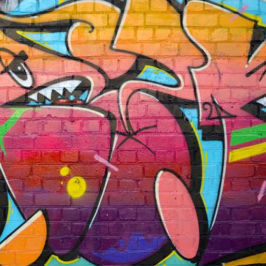Eski tuğla duvardaki graffiti resimlerinin soyut renkli bir parçası. Yazılmamış mektupların ve renkli lekelerin olduğu sokak sanatı kompozisyonu. Kırmızı renklerde alt kültür arkaplan dokusu