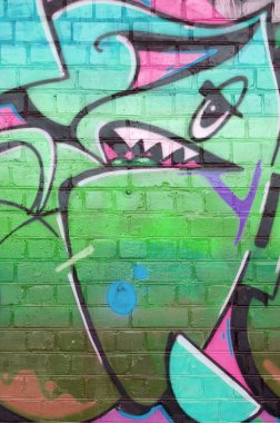 Pembe ve yeşil renklerde eski tuğla duvarlara çizilen graffiti resimlerinin soyut bir parçası. Yazılmamış mektupların ve renkli lekelerin olduğu sokak sanatı kompozisyonu. Alt kültür arka planı