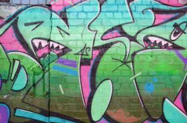 Pembe ve yeşil renklerde eski tuğla duvarlara çizilen graffiti resimlerinin soyut bir parçası. Yazılmamış mektupların ve renkli lekelerin olduğu sokak sanatı kompozisyonu. Alt kültür arka planı