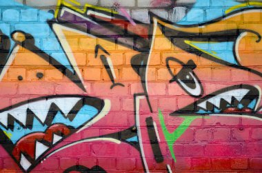 Eski tuğla duvardaki graffiti resimlerinin soyut renkli bir parçası. Yazılmamış mektupların ve renkli lekelerin olduğu sokak sanatı kompozisyonu. Kırmızı renklerde alt kültür arkaplan dokusu