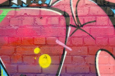 Eski tuğla duvardaki graffiti resimlerinin soyut renkli bir parçası. Yazılmamış mektupların ve renkli lekelerin olduğu sokak sanatı kompozisyonu. Kırmızı renklerde alt kültür arkaplan dokusu