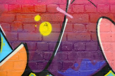 Eski tuğla duvardaki graffiti resimlerinin soyut renkli bir parçası. Yazılmamış mektupların ve renkli lekelerin olduğu sokak sanatı kompozisyonu. Kırmızı renklerde alt kültür arkaplan dokusu