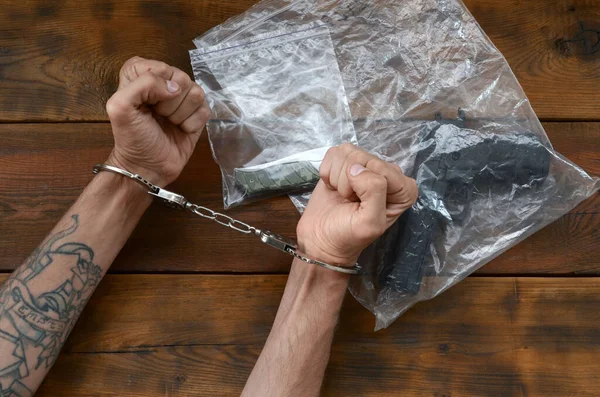 Mãos Algemadas Suspeito Criminoso Mesa Madeira Provas Cena Crime Embalagens — Fotografia de Stock