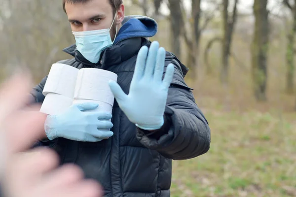 Koncepcja Covidiota Młody Człowiek Masce Ochronnej Trzyma Wiele Rolek Papieru — Zdjęcie stockowe