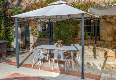 Bahçedeki sandalyeli yemek masası.