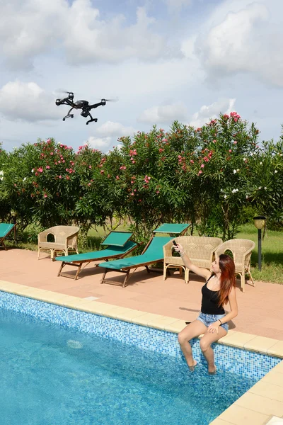 Chica volar drone con control remoto por la piscina — Foto de Stock