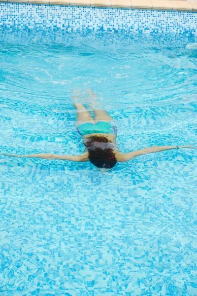 Schöne junge Frau entspannt im Wasser am Swimmingpool — Stockfoto