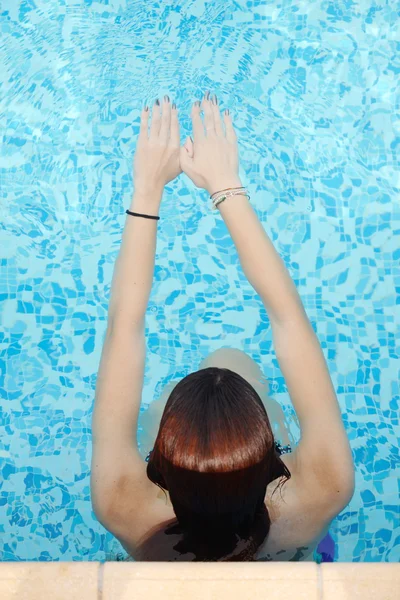 Schöne junge Frau entspannt im Wasser am Swimmingpool — Stockfoto