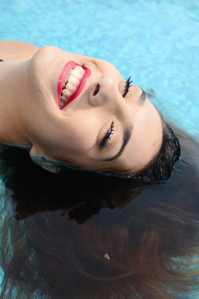 Güzel genç kadın su yüzme havuzu tarafından rahatlatıcı — Stok fotoğraf