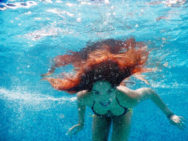 Jeune femme heureuse portrait sous l'eau au bord de la piscine — Photo