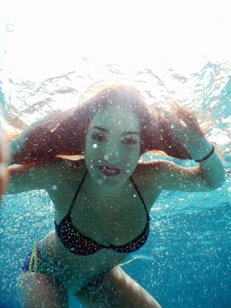 Νεαρή γυναίκα ευτυχισμένη πορτρέτο υποβρύχια δίπλα στην πισίνα — Φωτογραφία Αρχείου