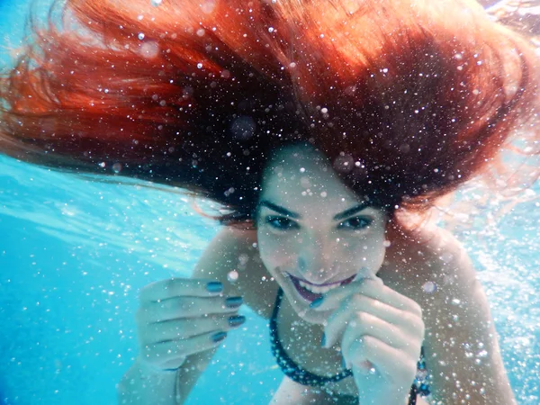 Jeune femme heureuse portrait sous l'eau au bord de la piscine — Photo