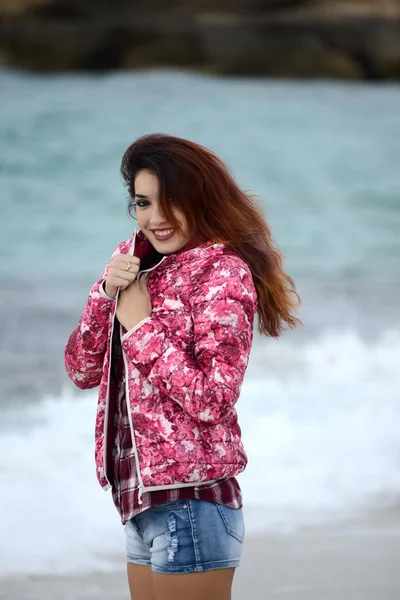 Menina bonita com blusão colorido andando na praia — Fotografia de Stock