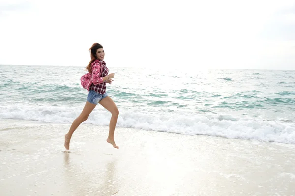 多彩的风衣，运行在海滩上的漂亮女孩 — 图库照片