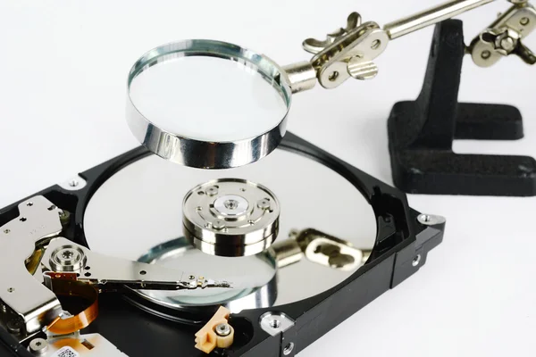 Closeup - hard disk repair  and magnifying glass — Stock Photo, Image
