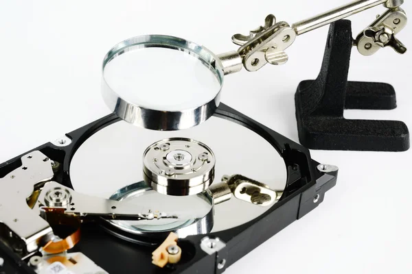 Closeup - hard disk repair  and magnifying glass — Stock Photo, Image