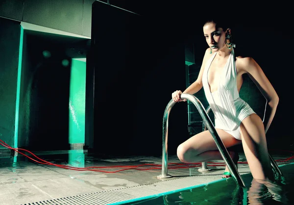 Modefrau im Badeanzug im grünen Pool — Stockfoto