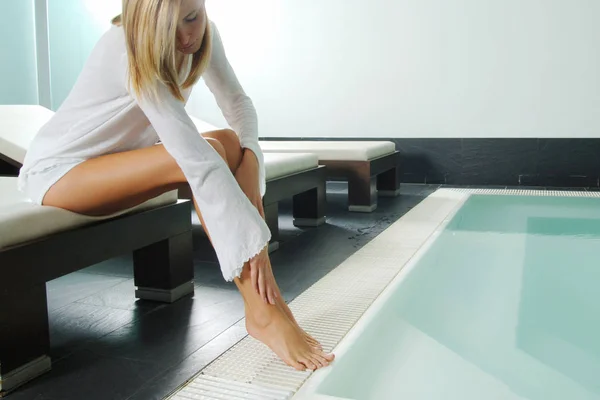 Женщина с сексуальными ногами отдыхает в воде у бассейна — стоковое фото