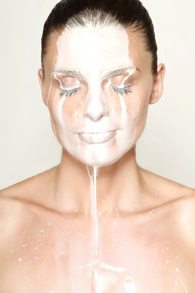 아름 다운 여자는 얼굴에 우유를 부 어 — 스톡 사진