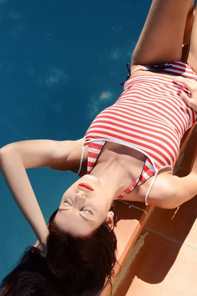 Красива щаслива жінка засмагає розслабляється біля басейну — стокове фото