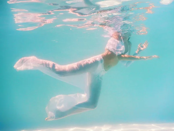 Vrouw mooi lichaam onderwater zwemmen in witte jurk — Stockfoto