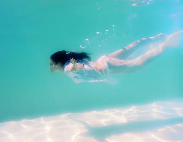 Женщина красивое тело плавать под водой в белом платье — стоковое фото