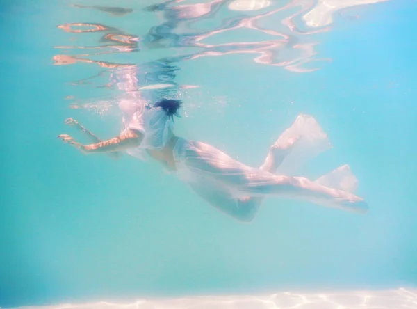 Mulher belo corpo nadar debaixo d 'água em vestido branco — Fotografia de Stock