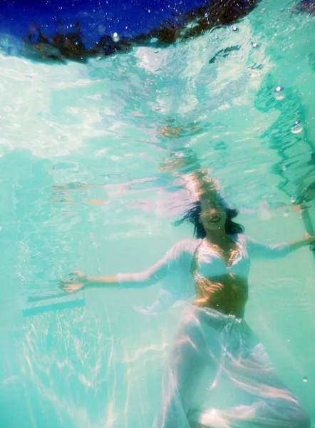 여성의 아름 다운 시체 흰색 드레스에 수 중 수영 — 스톡 사진