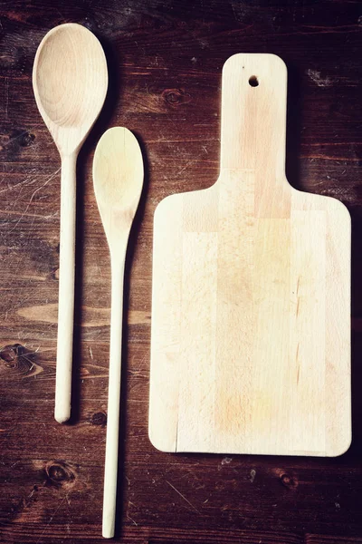 wooden spoon and  chopping board on dark wooden table