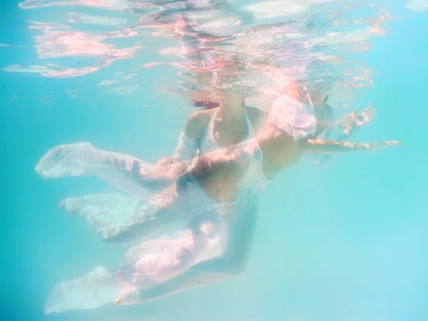 Mujer hermoso cuerpo nadar bajo el agua en vestido blanco —  Fotos de Stock