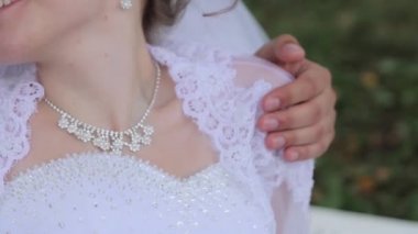mutlu gelin ve damat sarılma ve Park arka plan üzerinde gülümseyen