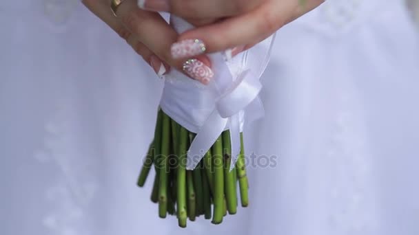 Schöner Brautstrauß in den Händen der jungen Braut. — Stockvideo