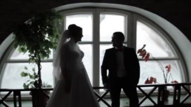 Damat ve gelin pencerenin önünde duruyor. İnsan siluetleri. Siyah beyaz resim.