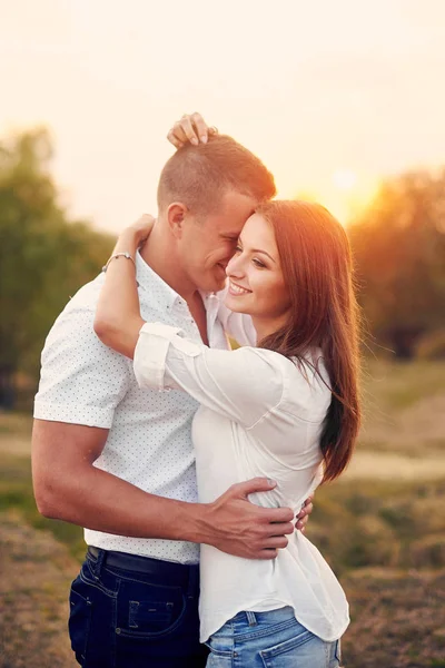 Glückliches Paar Händchen haltend und gemeinsam im Freien bei Sonnenuntergang — Stockfoto