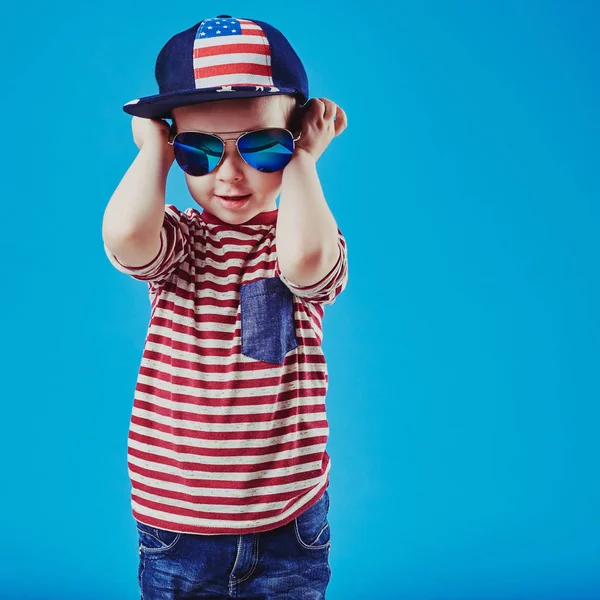 Mignon petit garçon en vêtements élégants et lunettes de soleil. Mode enfants . — Photo