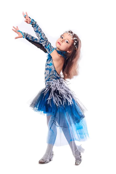 Маленькая танцовщица позирует с поднятой ногой в кедах и костюме — стоковое фото