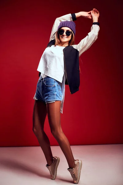 Retrato de moda mujer bonita en estilo de calle sobre fondo rojo — Foto de Stock