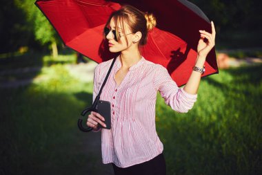 Kadın sokakta bir şemsiye altında bir akıllı telefon üzerinde söz