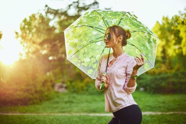 Çok renkli şemsiye tutan güzel genç bayan. Mavi gökyüzü açık havada. Kırsal manzara mutlu kız