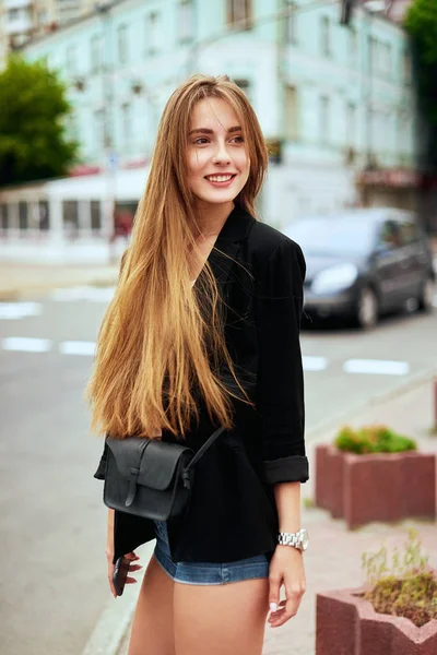 Дівчина гуляє по місту з телефоном і рюкзаком — стокове фото