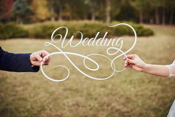 Hochzeit auf einem Teller grünen Hintergrund und einem Brunnen. Hochzeitsdekoration. Holztafel mit der Aufschrift Hochzeit. — Stockfoto