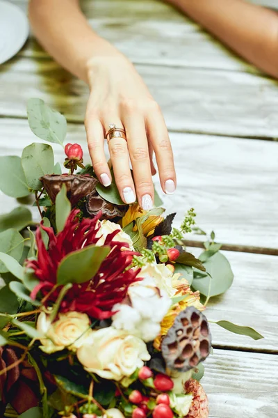 Vigselringar, Kista, brudens händer, färska blommor — Stockfoto