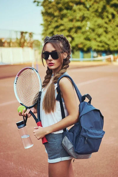 Meisje in sportkleding serveert tennisbal — Stockfoto