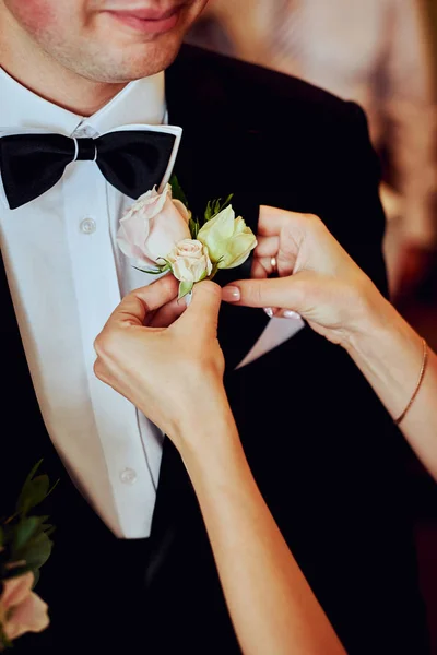 Die Braut trägt ein Knopfloch für den Bräutigam. — Stockfoto