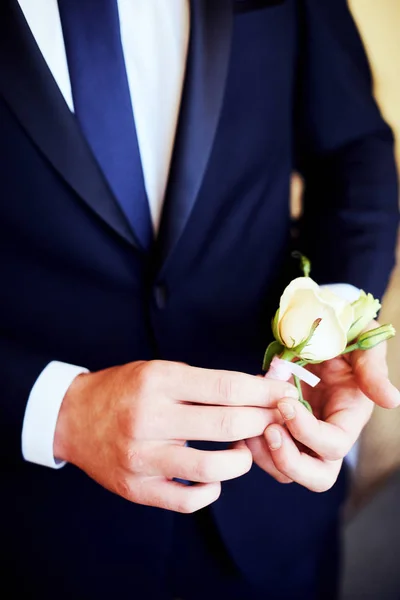 Die Braut trägt ein Knopfloch für den Bräutigam. — Stockfoto