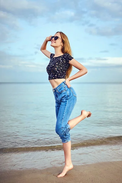 Fiesta chica bailando y agitando las manos en la playa sobre el cielo azul —  Fotos de Stock
