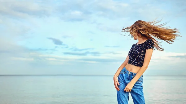 Part flicka dans och viftande händer på stranden under blå himmel — Stockfoto