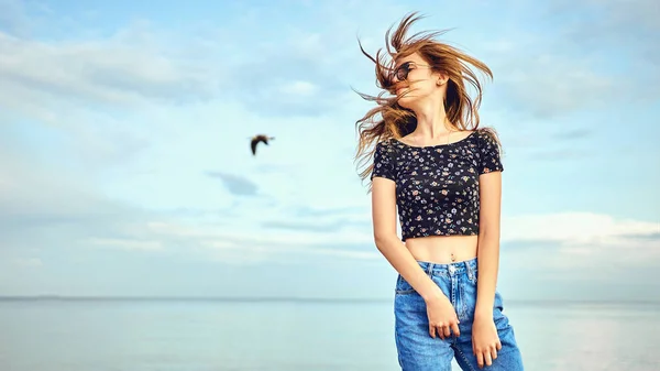 Fiesta chica bailando y agitando las manos en la playa sobre el cielo azul — Foto de Stock