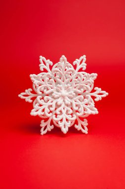 Kırmızı zemin üzerinde parıltılı beyaz kar taneleri